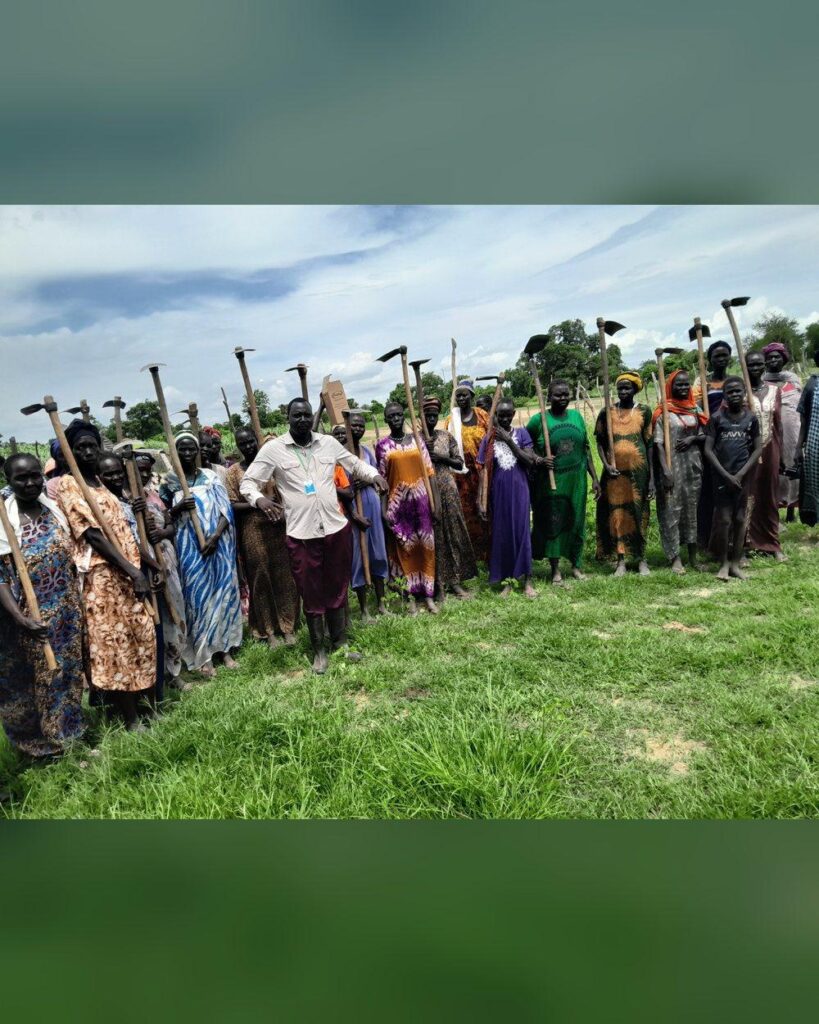 Women farmers with hoes at a community mobilization in Northern Bahr el Ghazal